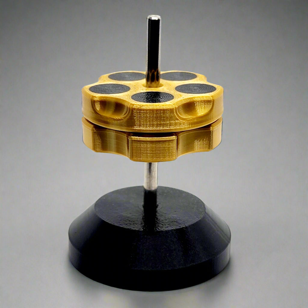 A dual-sided gold-colored magnetic fidget with a black levitating base, designed for flip, slide, and pop actions.